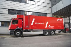 roter pistor elektro lkw vor gebaeude