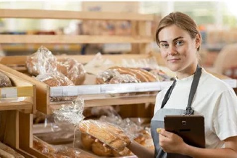 Bäckerin neben einem Brot Regal